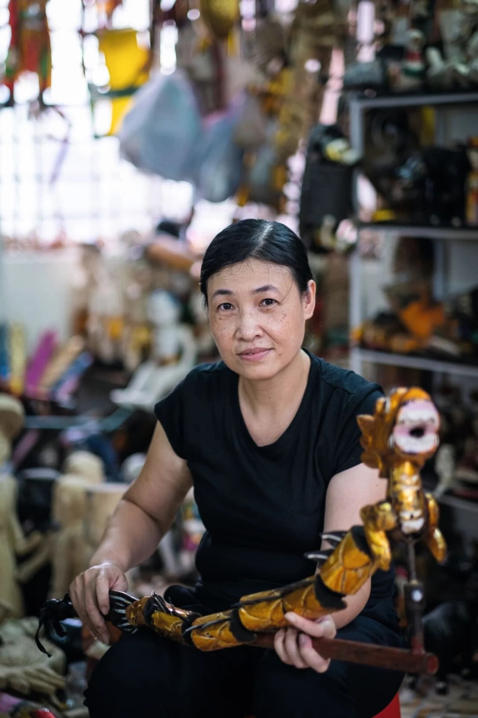 Hanoi water puppeteer Nguyen Thi Minh Loan holding a wooden dragon puppet
