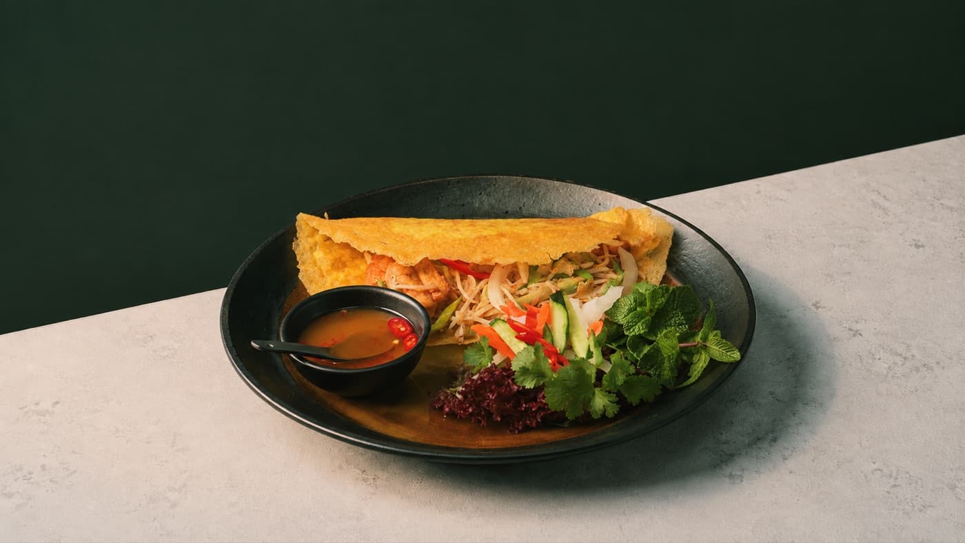Golden Saigon xeo pancake with fresh herbs